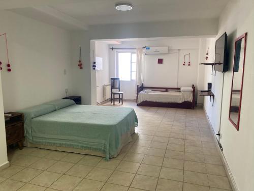Un dormitorio con dos camas y una mesa y una silla. en Departamento Belgrano 12, en Salta
