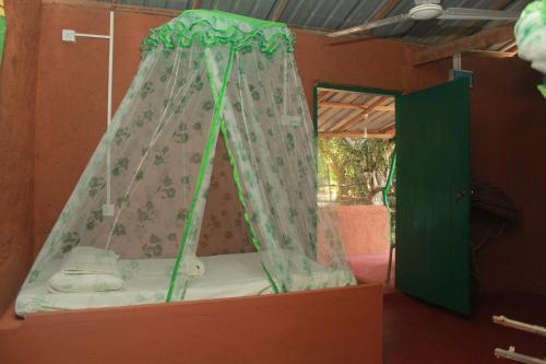 Yala Wild House في يالا: سرير في غرفة بها مظلة