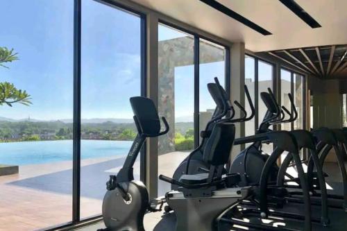 a gym with a row of exercise bikes in front of a window at Hani Homestay WiFi Netflix Secure parking KLIA USIM INTI Aeon mall in Nilai