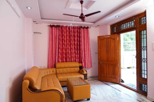 - un salon avec un canapé et un rideau rouge dans l'établissement Blue stone homestay guesthouse, à Visakhapatnam