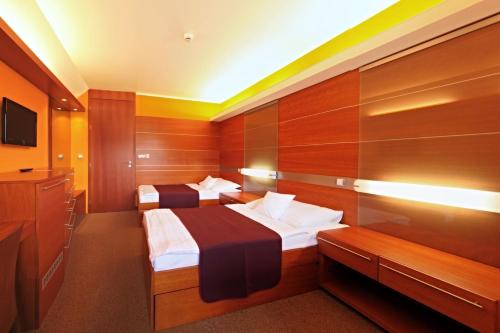 um quarto de hotel com duas camas e uma televisão em Hotel VZ Měřín em Merin