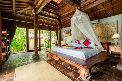 a bedroom with a bed with a canopy at Magatama Villa by Mahaputra in Gianyar