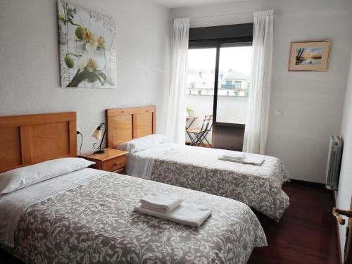 a hotel room with two beds and a window at DÚPLEX SANABRIA in El Puente