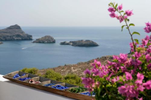 a wooden boat sitting on a table with flowers at Melenos Art Boutique Hotel in Líndos