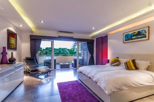 a bedroom with a large bed with a purple rug at Dasiri Beach Apartment Wongamat in North Pattaya