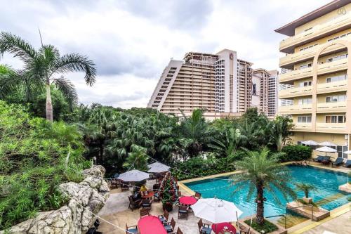 a view of a resort with a pool and a building at Dasiri Beach Apartment Wongamat in North Pattaya