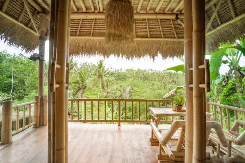 a porch of a resort with a table and chairs at Magatama Villa by Mahaputra in Gianyar