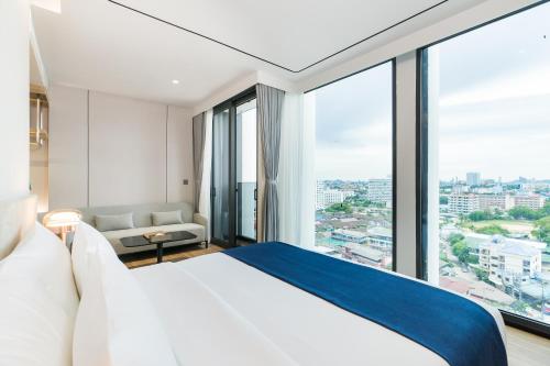 a hotel room with a bed and a large window at Arbour Hotel and Residence in Pattaya Central