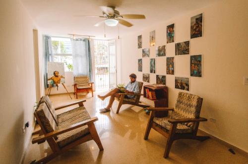 einem Mann, der in einem Wohnzimmer mit Stühlen sitzt in der Unterkunft Bodhi Panama City in Panama-Stadt