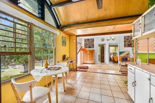 a kitchen with a table and chairs in a room at Cottonwood Cottage - Couples 'pet friendly' retro escape in Mudjimba