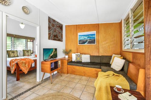 a room with a couch and a bed and a desk at Cottonwood Cottage - Couples 'pet friendly' retro escape in Mudjimba