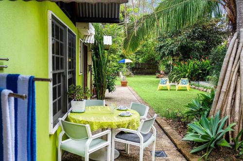 a patio with a table and chairs in a yard at Cottonwood Cottage - Couples 'pet friendly' retro escape in Mudjimba