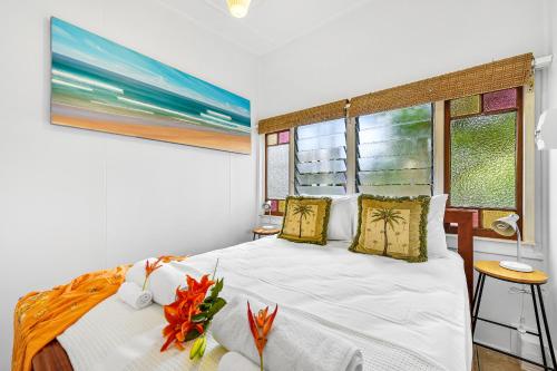 a bedroom with a white bed and a window at Cottonwood Cottage - Couples 'pet friendly' retro escape in Mudjimba