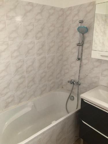 une salle de bain avec une baignoire blanche et un lavabo dans l'établissement Kennedy, à Saint-Jean-de-Braye