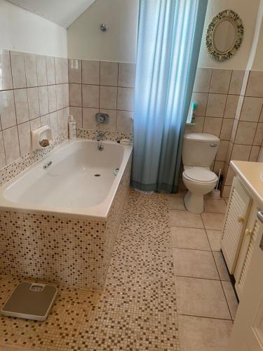 ein Badezimmer mit einer Badewanne, einem WC und einem Waschbecken in der Unterkunft Haus Panorama-3 bedrooms with great views in Lüderitz