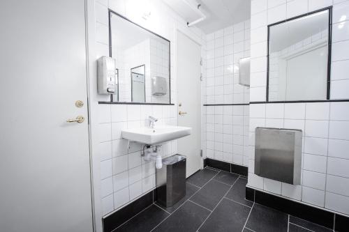 uma casa de banho branca com um lavatório e um espelho em Grebys Hotell & Restaurang em Grebbestad