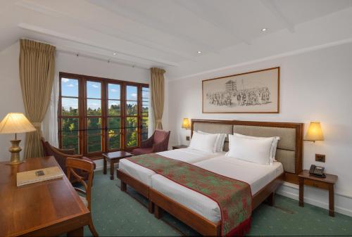 
a hotel room with a large bed and a large window at Heritance Tea Factory in Nuwara Eliya
