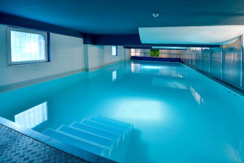 a swimming pool with blue lighting in a building at Plus Prague in Prague