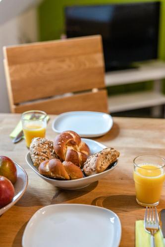a table with plates of pastries and glasses of orange juice at Schieners Hotel & Apfelhof Apartments in Wemding
