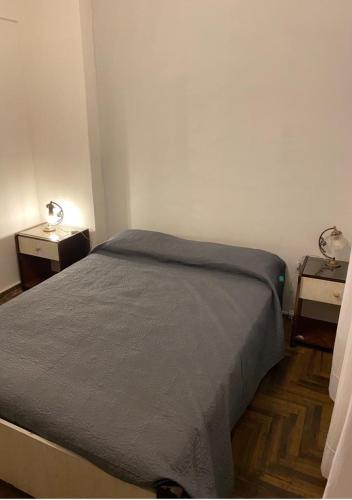 ein Bett in einem Zimmer mit zwei Nachttischen und zwei Tischen in der Unterkunft Salta & Luro in Mar del Plata