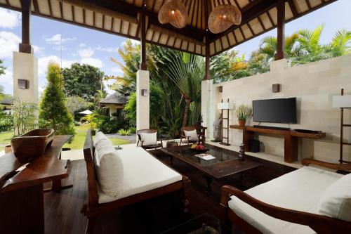 ein Wohnzimmer mit weißen Möbeln und einem Flachbild-TV in der Unterkunft Villa Nelayan by Nakula in Canggu