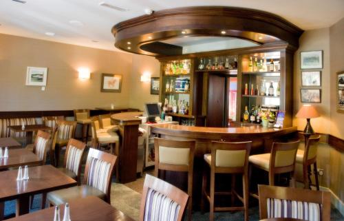 a restaurant with a bar and tables and chairs at Aherne's Townhouse Hotel and Seafood Restaurant in Youghal