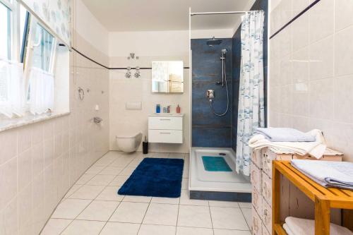 een badkamer met een douche en een blauw tapijt bij Residenz Bellevue Fewo 30 Fewo cc Herrmann in Zinnowitz