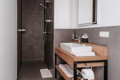 a bathroom with a sink and a shower at STEP INN The Fair Hotel in Rosbach vor der Höhe