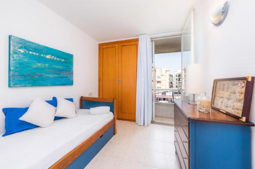 a bedroom with a bed with blue and white pillows at Angy Apartment in Alcudia