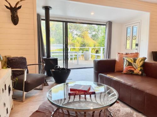 a living room with a couch and a glass table at Château Rosemund - ‘Your home away from home’. in Daylesford