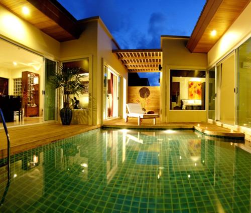 a swimming pool in front of a house at Karon Beach Walk Villa in Karon Beach