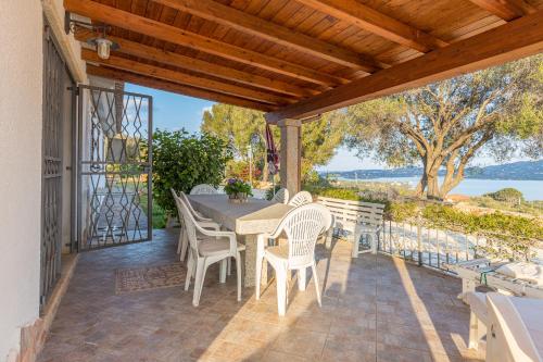 um pátio com uma mesa e cadeiras num deque em Bella Vista With Sea View - Happy Rentals em Cugnana