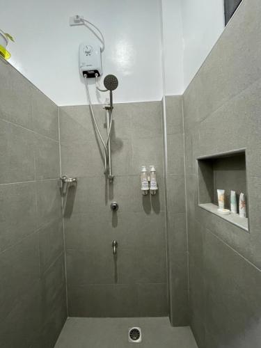 a shower with a shower head in a bathroom at Thistle Inn in Panglao