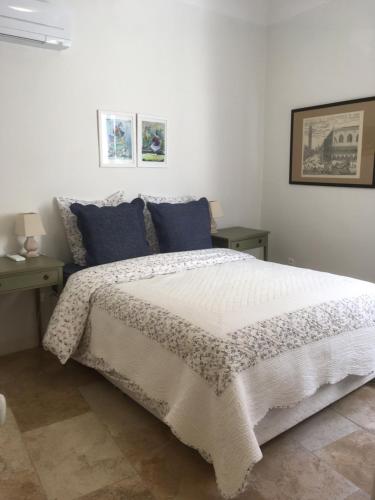 - une chambre avec un grand lit blanc et des oreillers bleus dans l'établissement Coeur de l'Arquet, à LʼIsle-sur-la-Sorgue