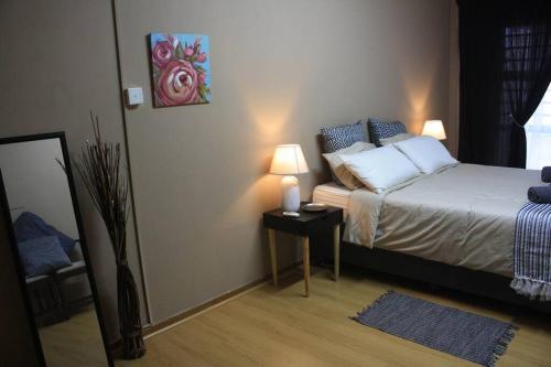 a bedroom with a bed with two lamps on a table at Casa en Gregg -Exquisite 2-bedroom self catering unit - 1 car parking space in East London
