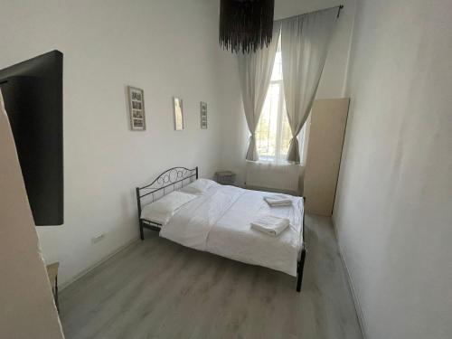 een witte slaapkamer met een bed en een raam bij The Floor Piata Unirii in Boekarest