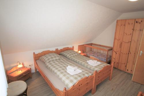 - une chambre avec un lit en bois et 2 tables de chevet dans l'établissement Ferienwohnung An der Poggenburg, à Hage