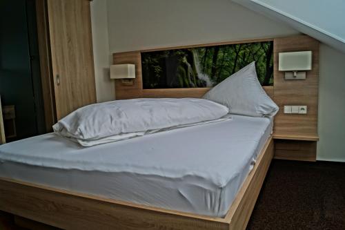 a large bed with white sheets and pillows at Gasthof Lamm in Grabenstetten