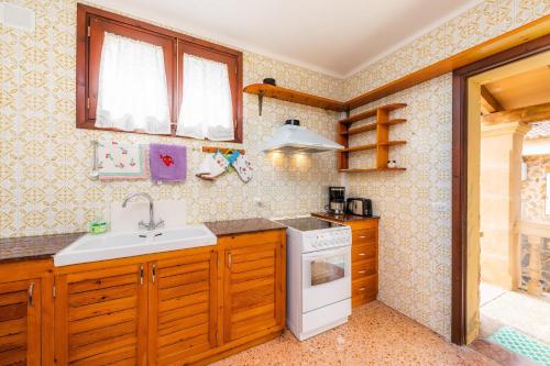 uma cozinha com um lavatório e um fogão forno superior em Casa Isabel y Mateo em Cala de Sant Vicent