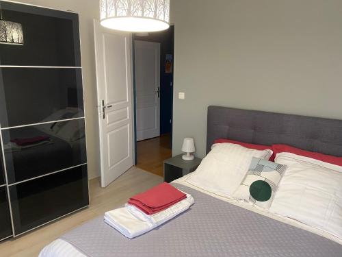 une chambre avec un grand lit avec des oreillers rouges et blancs dans l'établissement LES TERRASSES, à Amiens