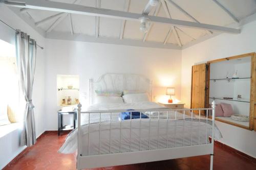 um quarto com uma cama branca num quarto em LOVELY QUIET HOUSE WITH GARDEN em Spetses