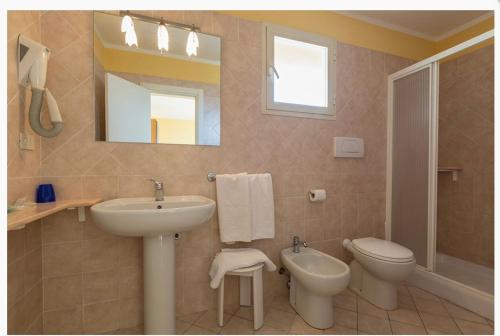 a bathroom with a sink and a toilet and a mirror at Hotel San Carlo in Marina di Pietrasanta