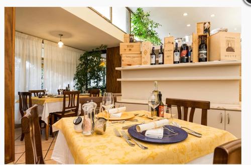 ein Esszimmer mit einem Tisch und einem gelben Tischtuch in der Unterkunft Hotel San Carlo in Marina di Pietrasanta