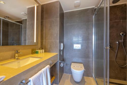 e bagno con doccia, servizi igienici e lavandino. di Akadia Luxury Sorgun - Adults Only 16 Plus a Side