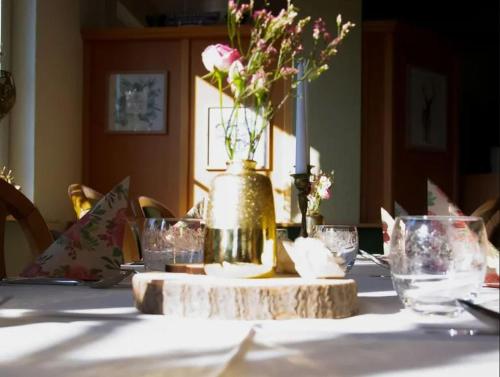 einen Tisch mit einer Blumenvase darüber in der Unterkunft Haus am Park in Bad Soden-Salmünster