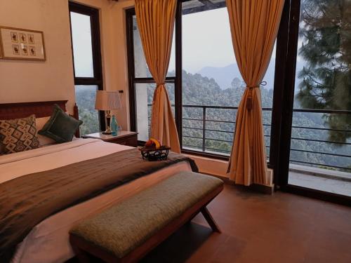 a bedroom with a large bed and large windows at BluSalzz Escapade, Lansdowne - Uttarakhand in Lansdowne