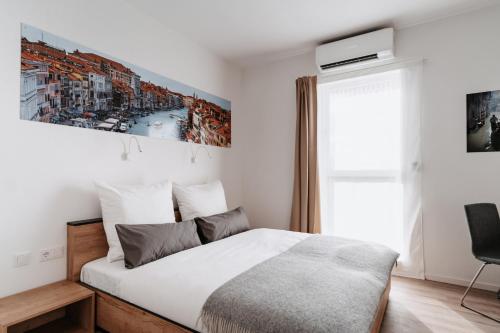 a bedroom with a bed and a painting on the wall at STEP INN The Fair Hotel in Rosbach vor der Höhe