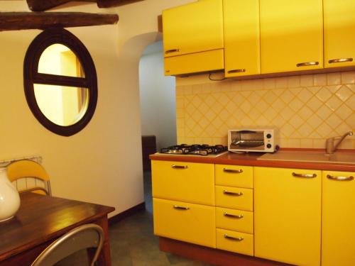 パレルモにあるAlberico Gentiliのキッチン(黄色のキャビネット、カウンタートップ付)