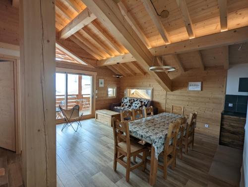 une salle à manger avec une table et des chaises dans l'établissement Les Chalets de l'Adret, au Grand-Bornand