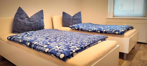 two beds with blue and white pillows on a table at Ferienwohnung am Birkenwäldchen in Plauen